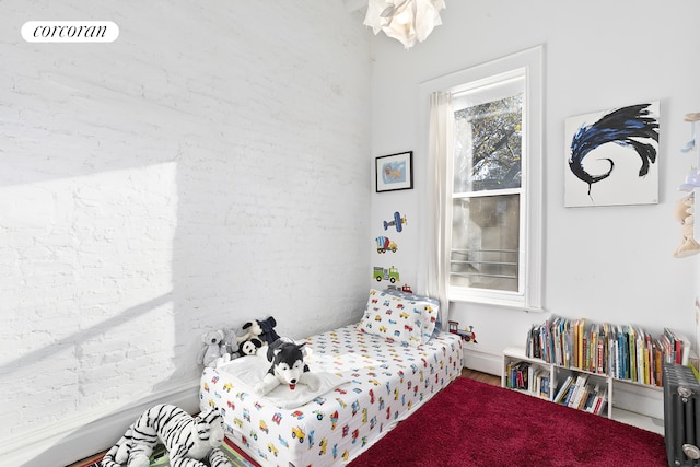 bedroom with radiator heating unit and wood finished floors