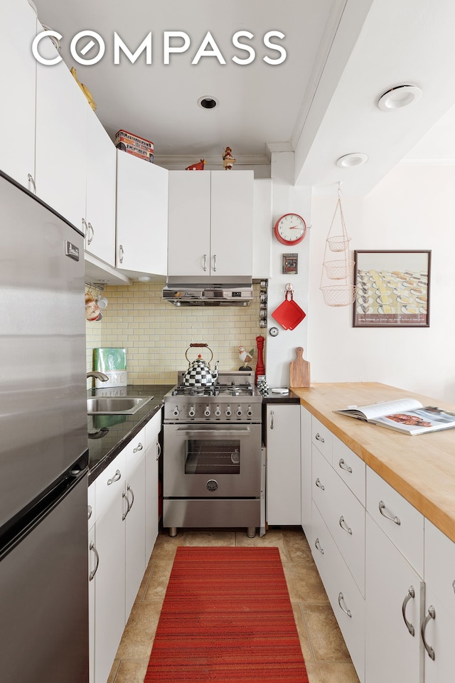 kitchen featuring crown molding, white cabinetry, under cabinet range hood, tasteful backsplash, and appliances with stainless steel finishes