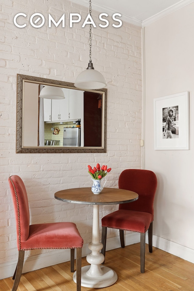 dining room featuring baseboards, ornamental molding, and wood finished floors