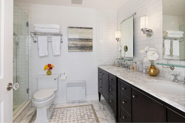 bathroom featuring a stall shower, toilet, double vanity, and marble finish flooring