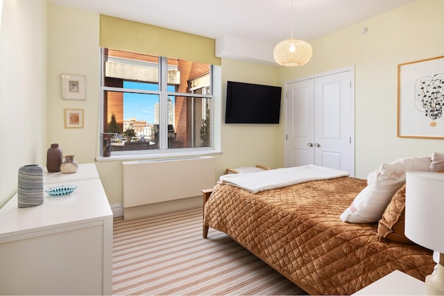 bedroom featuring light carpet and a closet