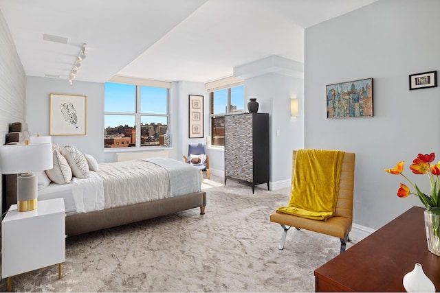 carpeted bedroom with rail lighting and baseboards