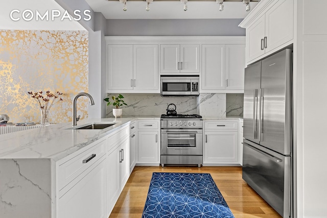330 Bergen St Unit 3D, New York City, NY 11217 - kitchen with premium appliances, a sink, a peninsula, and white cabinets