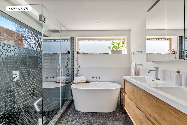 full bathroom with a stall shower, a freestanding tub, vanity, and speckled floor