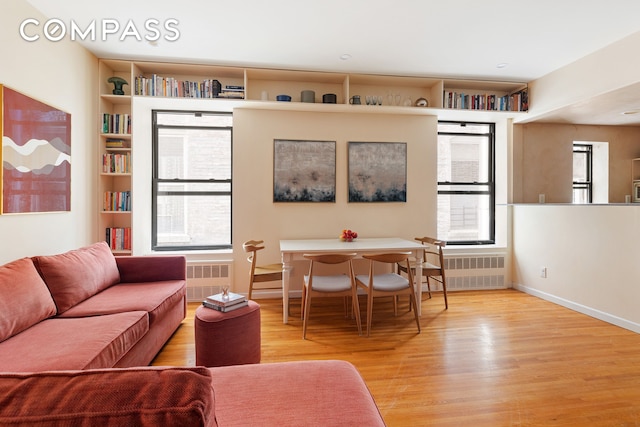 living area with wood finished floors, radiator heating unit, and baseboards