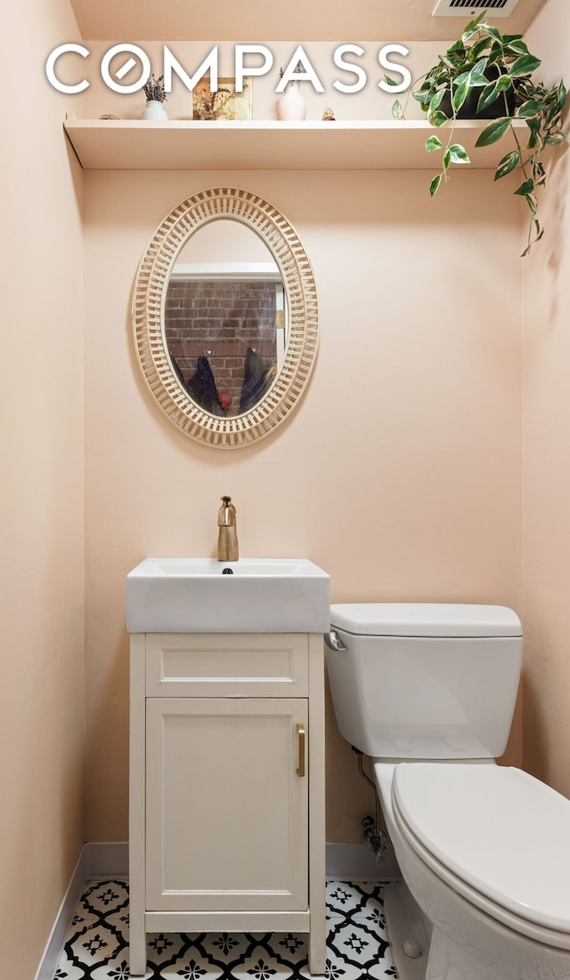 half bath with baseboards, toilet, and vanity