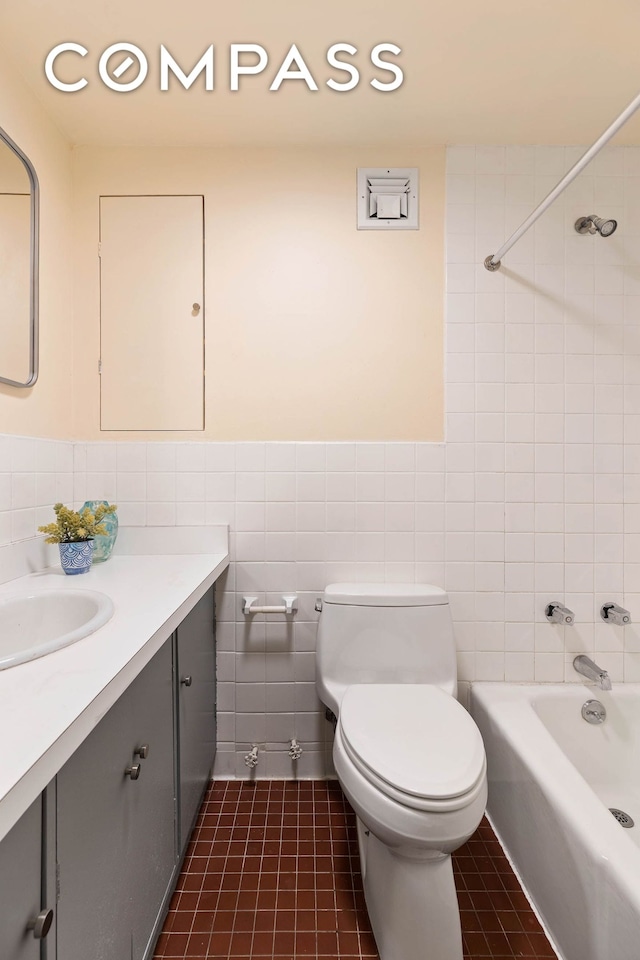 bathroom with tile walls, vanity, toilet, shower / tub combination, and wainscoting