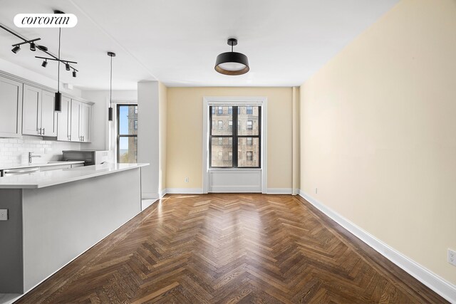 880 W 181st St Unit 4C, New York City, NY 10033 - kitchen featuring light countertops, pendant lighting, decorative backsplash, dishwashing machine, and rail lighting