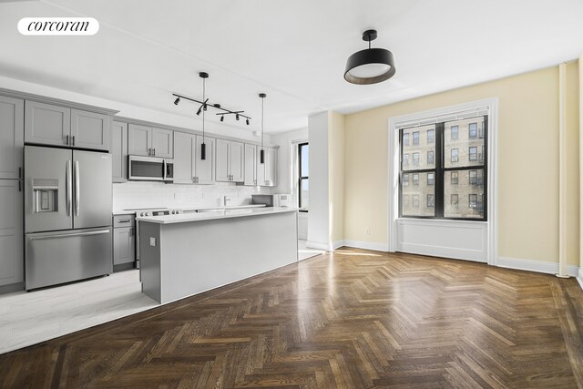 880 W 181st St Unit 4C, New York City, NY 10033 - kitchen with stainless steel appliances, decorative backsplash, light countertops, pendant lighting, and gray cabinets
