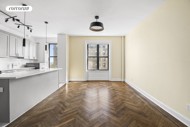 880 W 181st St Unit 4C, New York City, NY 10033 - kitchen with light countertops, decorative backsplash, hanging light fixtures, dishwasher, and rail lighting