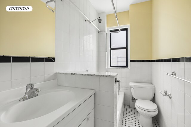 880 W 181st St Unit 4C, New York City, NY 10033 - bathroom featuring tile walls, vanity, tile patterned flooring, and washtub / shower combination