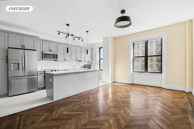 880 W 181st St Unit 4C, New York City, NY 10033 - kitchen with appliances with stainless steel finishes, light countertops, decorative backsplash, pendant lighting, and gray cabinetry