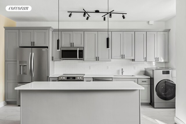 880 W 181st St Unit 4C, New York City, NY 10033 - kitchen featuring appliances with stainless steel finishes, washer / clothes dryer, gray cabinetry, and tasteful backsplash