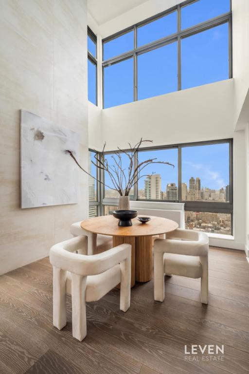 235 E 55th St Phb, Phb, New York City, NY 10022 - dining area featuring a towering ceiling, wood finished floors, and a city view