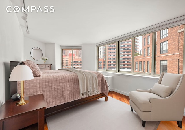 206 E 95th St Unit 10B, New York City, NY 10128 - bedroom featuring wood finished floors and rail lighting