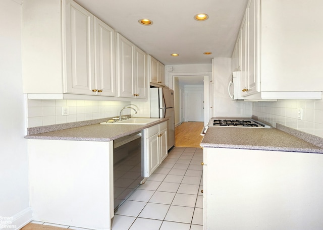 kitchen featuring white appliances, decorative backsplash, a sink, and light countertops