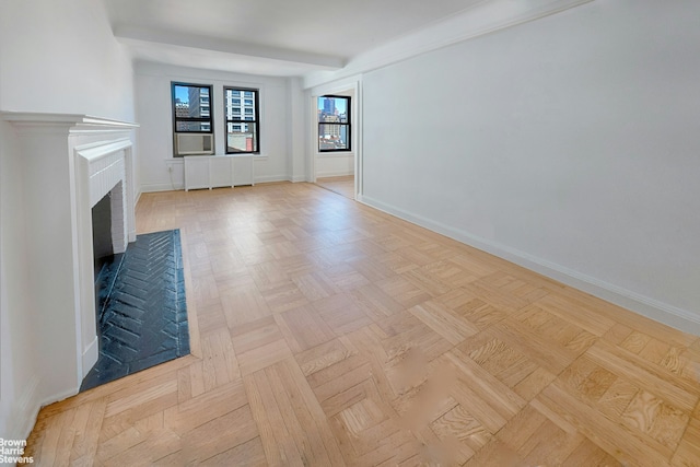 unfurnished living room featuring baseboards and a brick fireplace