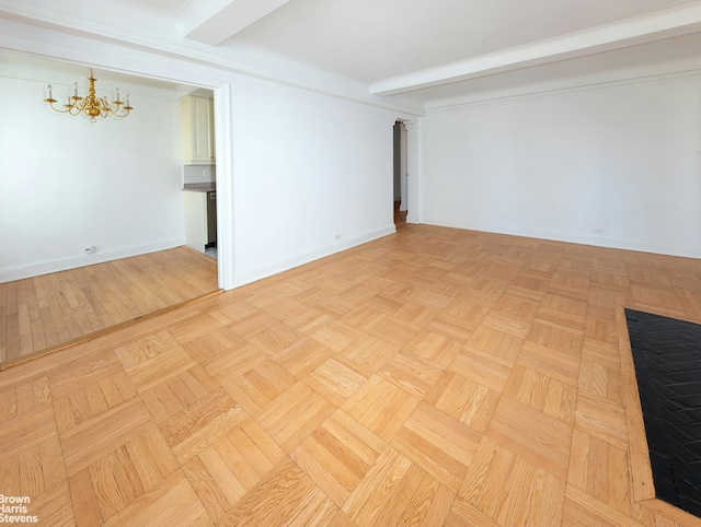 empty room with baseboards, a chandelier, and beam ceiling