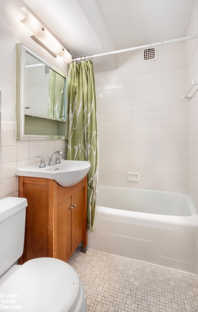 bathroom with toilet, shower / tub combo, tile walls, and vanity
