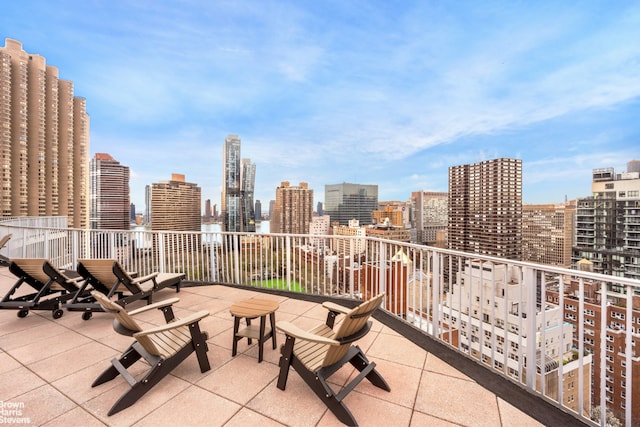 view of patio with a view of skyline and a balcony