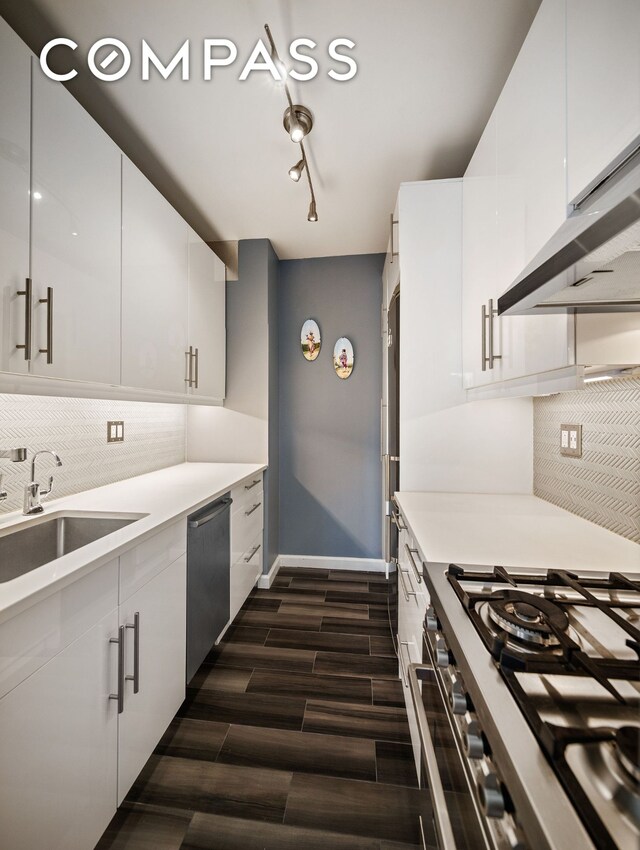 304 E 65th St Unit 10D, New York City, NY 10065 - kitchen featuring stainless steel appliances, wood tiled floors, backsplash, white cabinetry, and light countertops