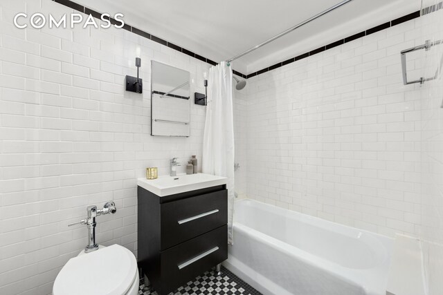 470 W 24th St Unit 2C, New York City, NY 10011 - full bathroom with tile walls, vanity, shower / tub combo, toilet, and tile patterned flooring