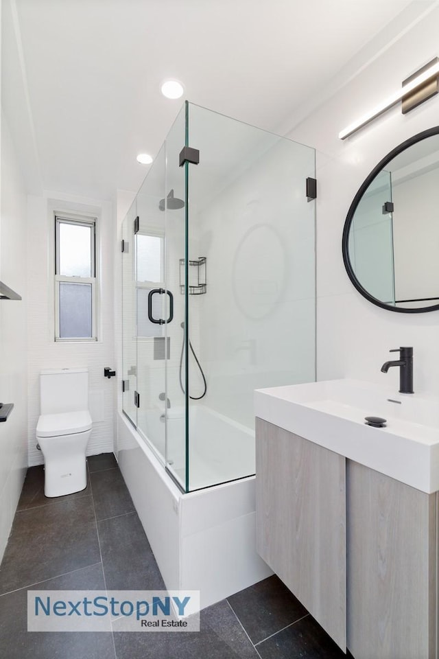 414 E 52nd St Unit 8F, New York City, NY 10022 - bathroom featuring bath / shower combo with glass door, toilet, vanity, tile patterned flooring, and recessed lighting