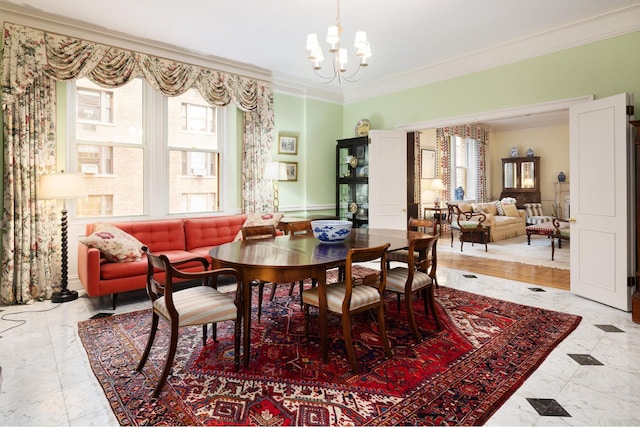 dining room featuring ornamental molding, a chandelier, and light marble finish flooring