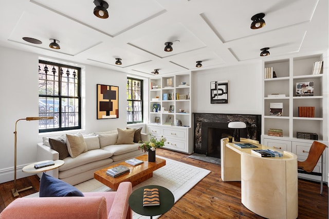 living area with a high end fireplace, built in features, beamed ceiling, coffered ceiling, and dark wood-type flooring