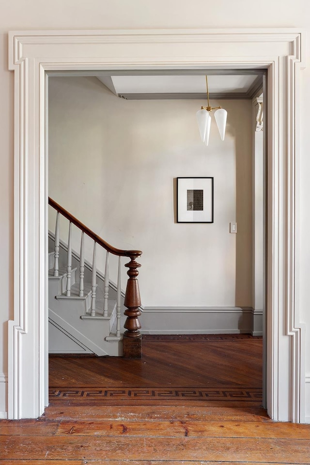 stairway with baseboards and hardwood / wood-style flooring
