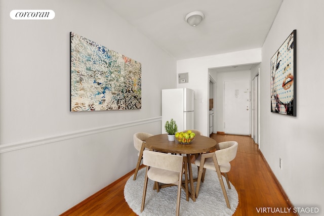 dining area featuring visible vents, baseboards, and wood finished floors