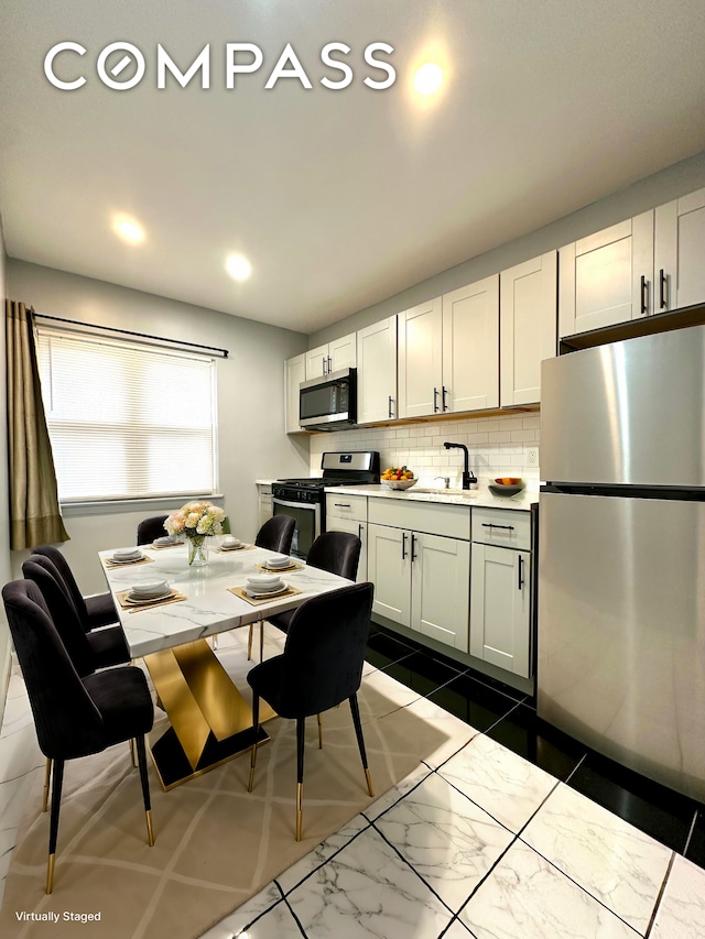 75-66 197th St, New York City, NY 11366 - kitchen with stainless steel appliances, decorative backsplash, a sink, light countertops, and recessed lighting