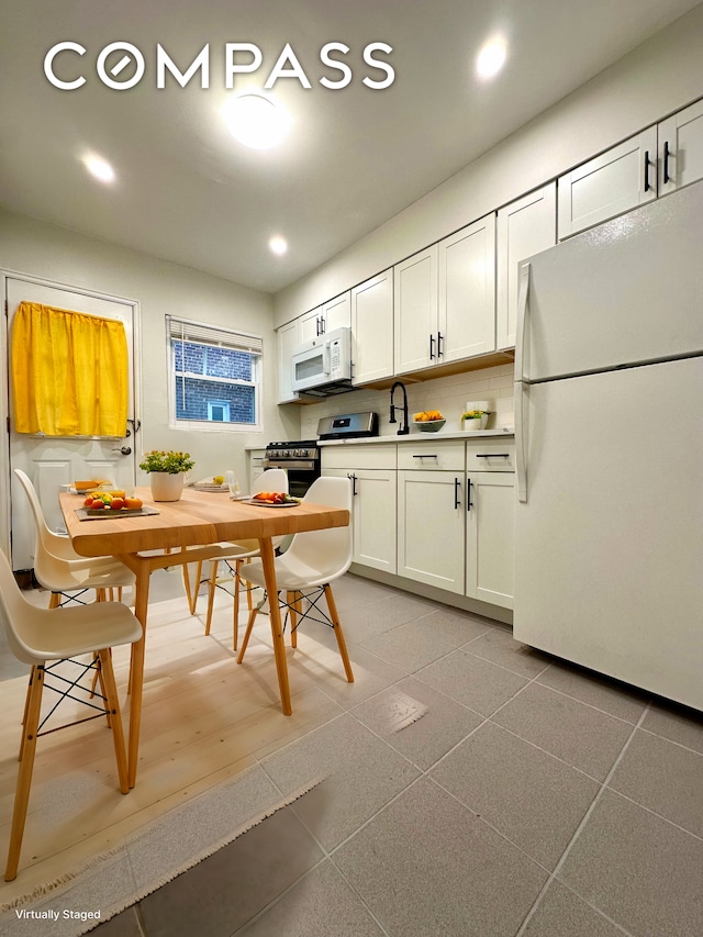 75-66 197th St, New York City, NY 11366 - kitchen featuring white appliances, recessed lighting, and white cabinetry