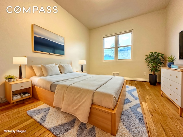 75-66 197th St, New York City, NY 11366 - bedroom featuring wood finished floors, lofted ceiling, and baseboards
