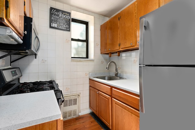 68 Stratford Rd Unit 1A, New York City, NY 11218 - kitchen with freestanding refrigerator, gas range, brown cabinetry, light countertops, and tile walls