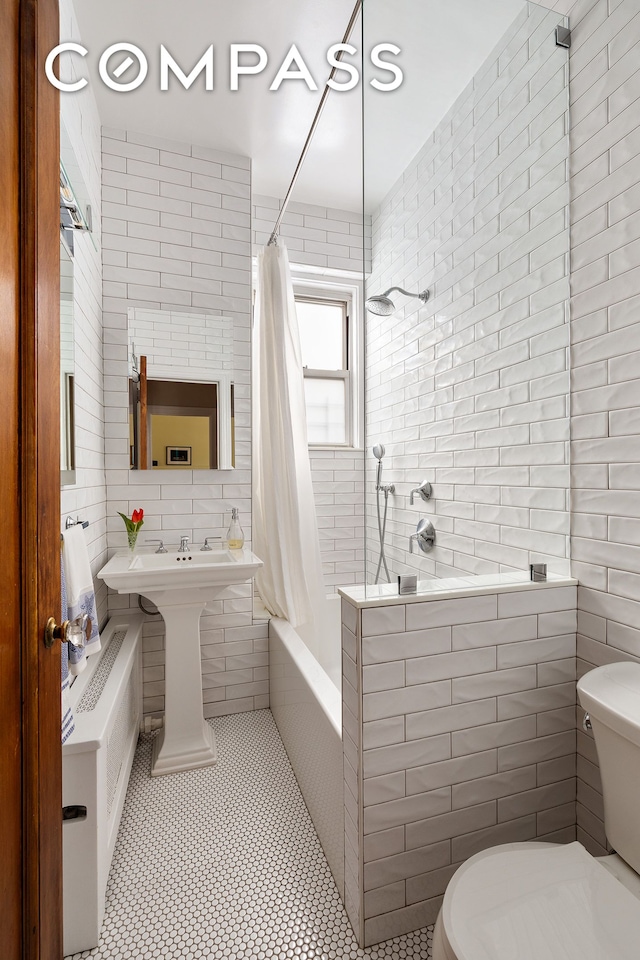 1349 Lexington Ave Unit 8C, New York City, NY 10128 - full bathroom featuring tile walls, toilet, tiled shower / bath combo, and tile patterned floors