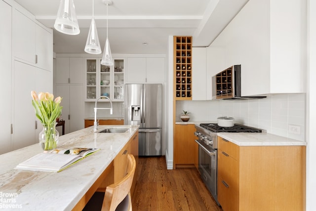 245 W 107th St Unit 4E, New York City, NY 10025 - kitchen with stainless steel appliances, a sink, dark wood-style flooring, light stone countertops, and a breakfast bar area