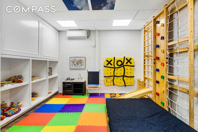 205 W 89th St Unit 6Rs, New York City, NY 10024 - recreation room with a wall mounted air conditioner, a drop ceiling, and brick wall