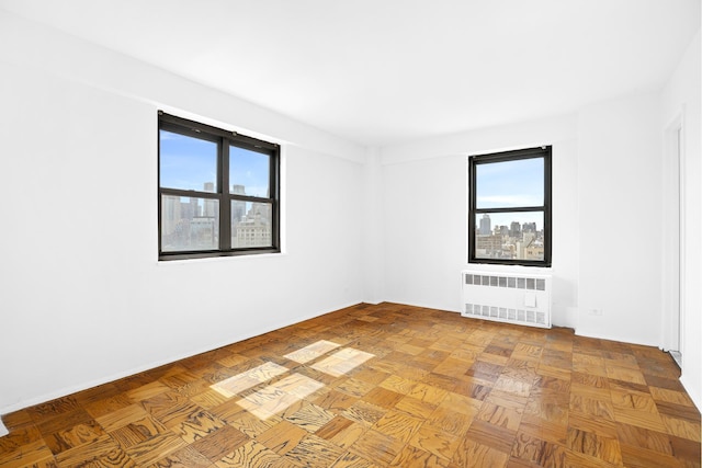spare room featuring radiator heating unit and baseboards