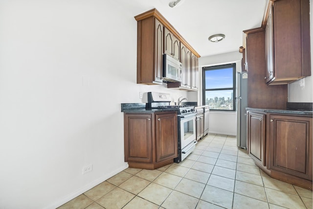 kitchen featuring stainless steel appliances, dark countertops, and baseboards