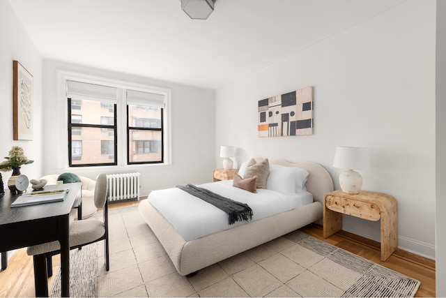 bedroom featuring radiator, light wood-type flooring, and baseboards