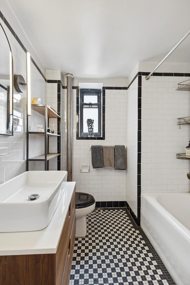 full bath featuring vanity, toilet, tile walls, bathtub / shower combination, and tile patterned floors
