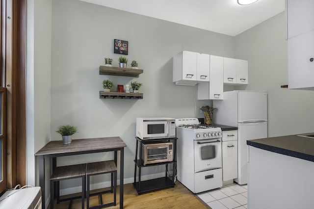 508 E 78th St Unit 4-G, New York City, NY 10075 - kitchen featuring white appliances, white cabinets, dark countertops, and open shelves