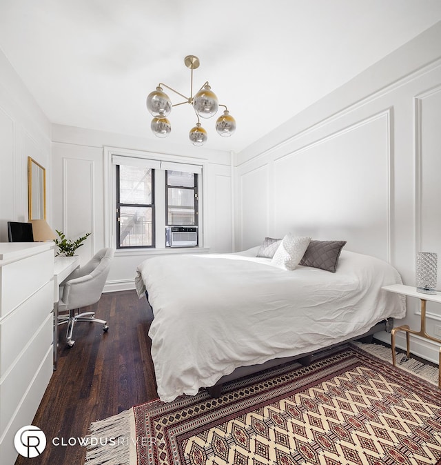bedroom with dark wood-style flooring, a decorative wall, a chandelier, and cooling unit
