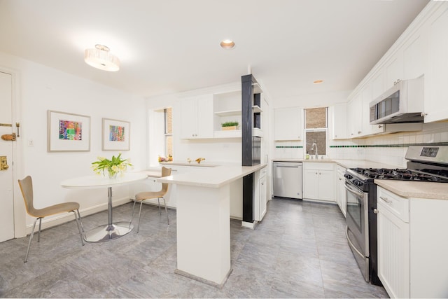 kitchen featuring appliances with stainless steel finishes, open shelves, light countertops, white cabinets, and recessed lighting