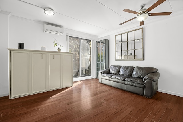 living room featuring an AC wall unit, ornamental molding, a ceiling fan, hardwood / wood-style floors, and baseboards