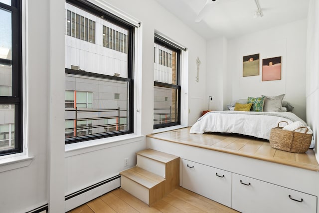 bedroom featuring light wood-style floors and rail lighting