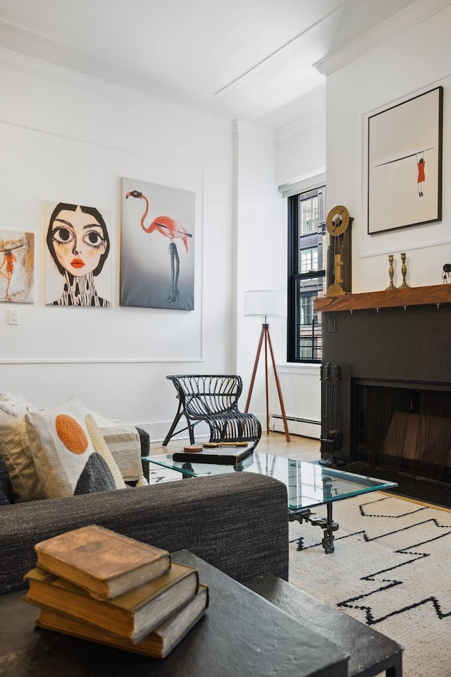 living area with a fireplace, crown molding, and a baseboard radiator