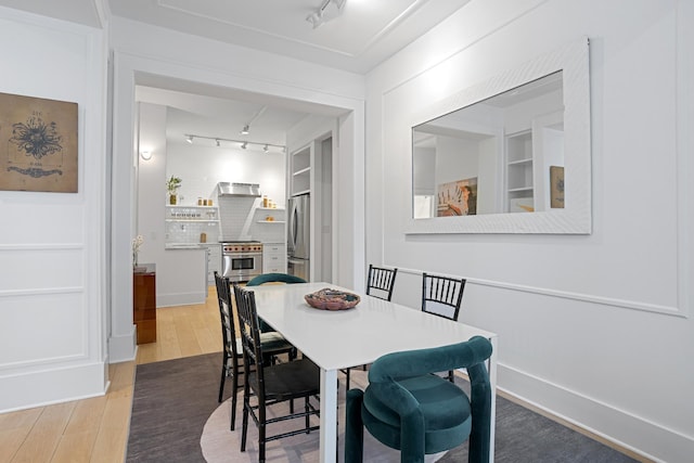 dining room featuring track lighting and wood finished floors