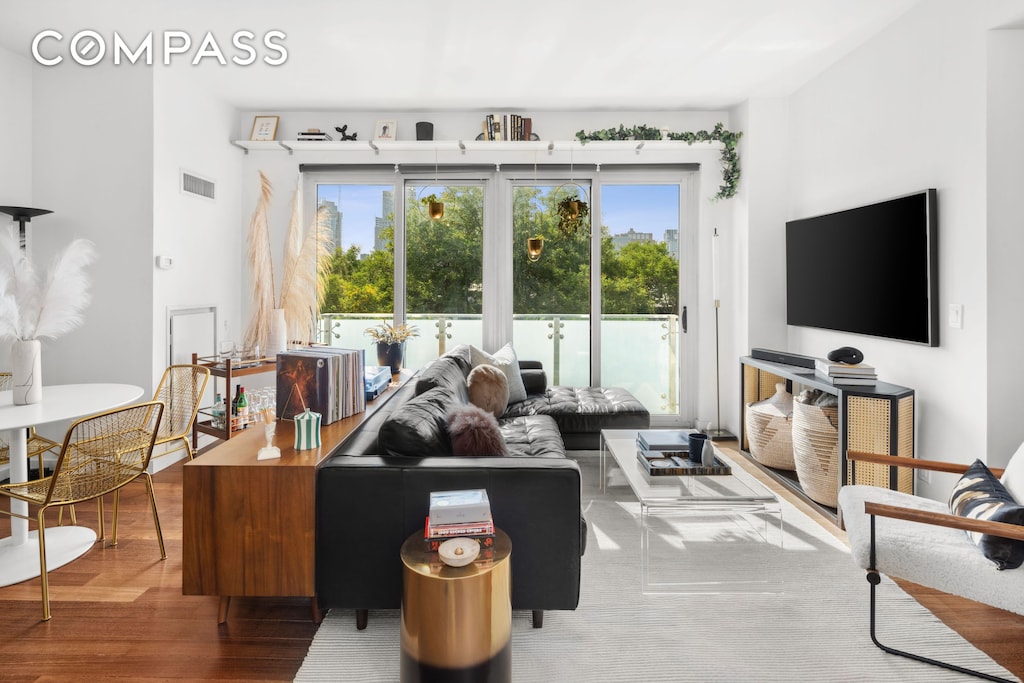 living area featuring visible vents and wood finished floors